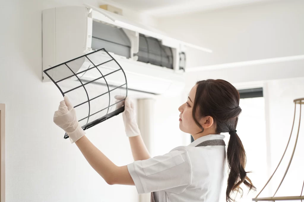 Homeowner changing the HVAC air filter to maintain system efficiency